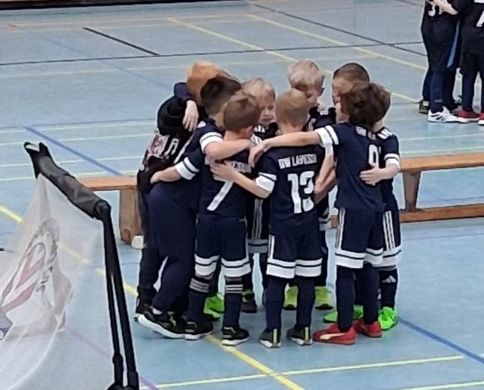 Kinder im Teamkreis auf dem Fußballplatz